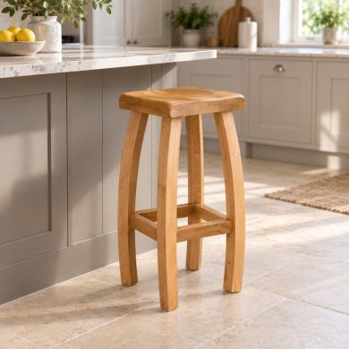 Bali solid oak kitchen stool with curved legs and footrests beside a painted kitchen island