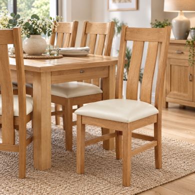 Churchill Solid Oak Cream Leather Assembled Dining Chair with curved slatted oak back and cream leather seat in a bright dining room