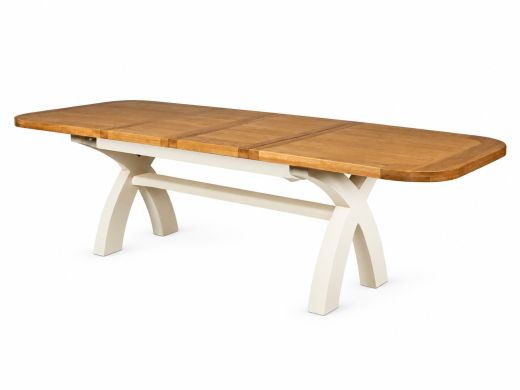 Country Oak cream painted cross leg dining table fully extended to 280cm with a rounded oak top on a white background