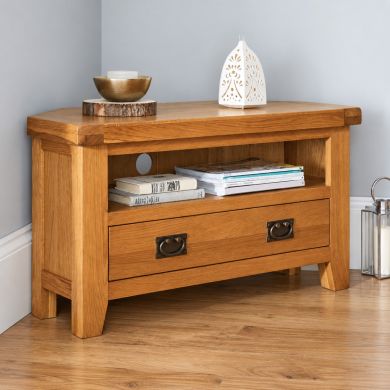 Country Oak assembled corner TV unit with open media shelf, wide drawer and two antique-style metal handles.