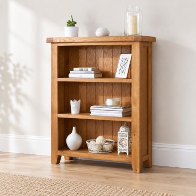 Country Oak small low fully assembled bookcase with three open storage shelves in a neutral lifestyle room setting