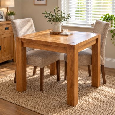Country Oak 80cm square chunky corner leg small dining table with two upholstered chairs in a bright modern dining room