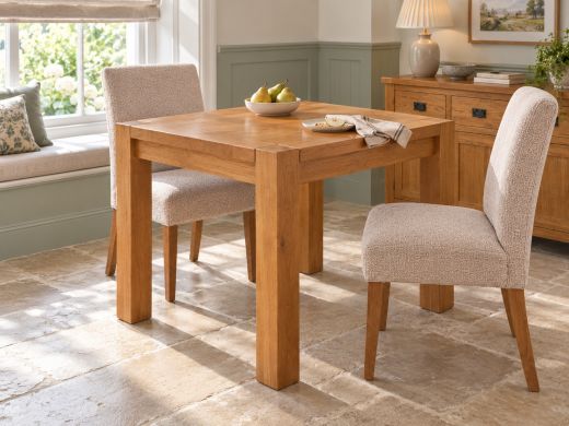 Country Oak 80cm square dining table with upholstered chairs in a sage-panelled breakfast nook with a window seat and oak sideboard