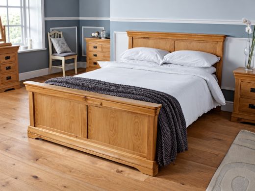 Farmhouse Country Oak 4ft 6in double bed with panelled oak headboard and footboard in a bedroom