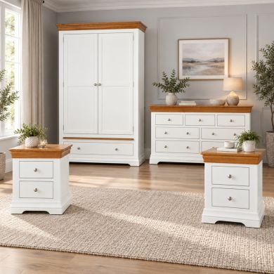Farmhouse white painted oak bedroom set with double wardrobe, large chest of drawers and two bedside tables in a bright bedroom