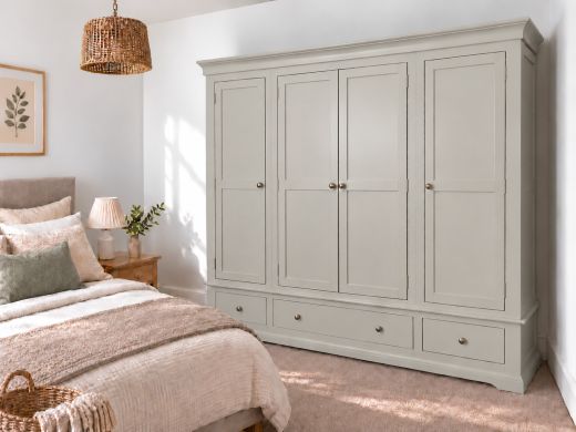 Toulouse grey painted four door wardrobe with three storage drawers in a softly styled neutral bedroom