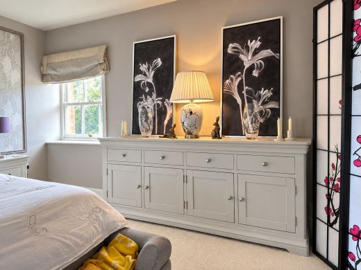 Toulouse 200cm grey painted sideboard with four drawers and four doors in a bedroom with botanical prints and a table lamp