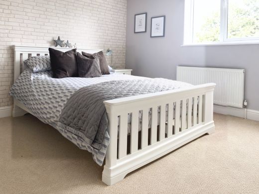 Toulouse white painted king size slatted bed with grey patterned bedding in a bright bedroom