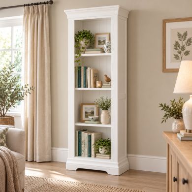 Toulouse White Painted Tall Narrow Bookcase styled with books, plants and decorative accessories in a bright neutral living room