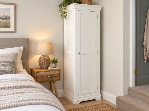 Toulouse White Painted Narrow Storage Cupboard in a warm neutral bedroom with wooden bedside table and woven lamp