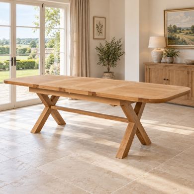 Provence 2.8m double extending oak dining table with rounded corners and cross legs, fully extended in a bright country dining room.