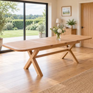 Provence 2.8m double extending oak dining table with rounded corners and cross legs, fully extended in a bright country dining room.