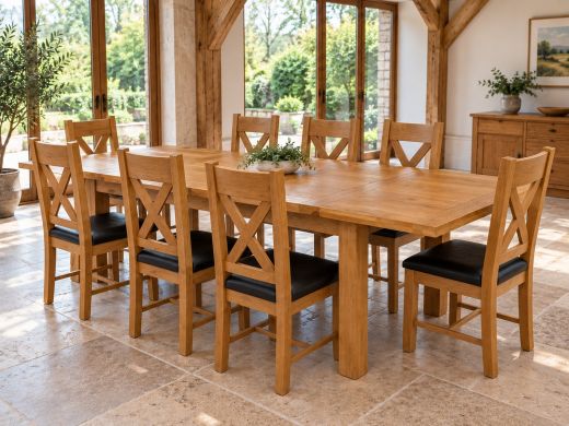 Country Oak extending dining table with eight cross-back chairs in a bright oak-beamed dining room