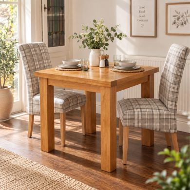 Country Oak 80cm small square oak dining table in a bright dining room with two upholstered chairs and neutral tableware
