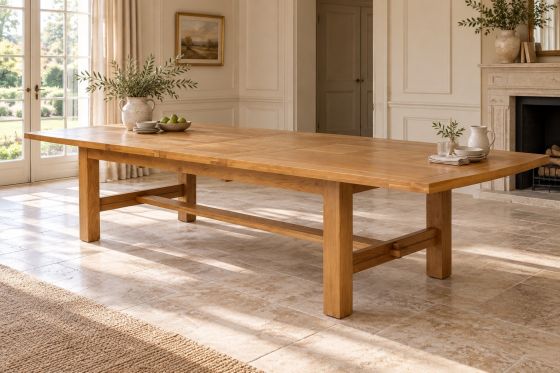 Chateaux solid oak extending dining table fully extended to 340cm in a light country house dining room, showing its centre extension leaves and stretcher base